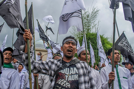 Protesters seen chanting slogans during the demonstration.
Muslims throughout Indonesia held protests against the burning of the Tauhid Islamic flag in front of the Lhokseumawe Islamic Center Mosque.
Violent protests by Indonesian Muslims after the circulation of videos of burning the Tauhid Islamic flag (La Illah ha illallah Muhammaddurrasulullah) by a number of BANSER (Multipurpose Ansor Barisan) members.