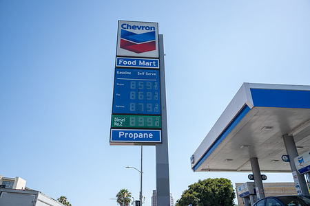Motorists refuel vehicles beneath fuel price signs displaying gasoline prices above $8 per gallon at a Chevron station in Los Angeles. Rising fuel costs continue to impact commuters across Southern California as inflation and global energy market pressures contribute to higher prices at the pump.