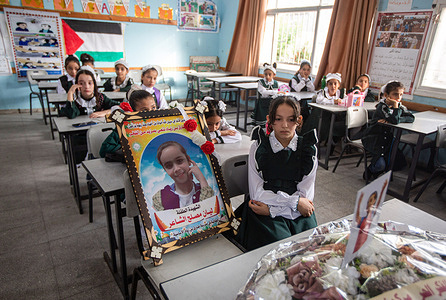 Friends of 11-year-old Palestinian student Lian Al Shaer get emotional over a picture of Lian, who was killed after sustaining injuries from the recent Israeli air strikes on the first day of the school year in Khan Yunis, southern Gaza Strip.