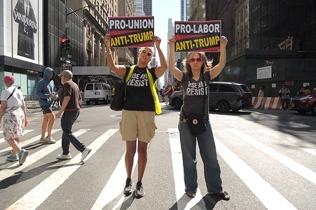 Anti-Trump demonstrators hold placards on the street on Fifth Avenue outside of Trump Tower. On Labor Day, demonstrators in Manhattan, protested against Donald Trump and demanded a higher wage for workers. Demonstrators also protested Trump’s federal takeover of the Washington, D.C. police force and using the National Guard in D.C. Furthermore, protesters condemned the Trump administration’s immigration policies and U.S. Immigration and Customs Enforcement or ICE for arresting and deporting immigrants.