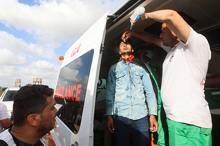 Palestinian medics give treatment to a wounded man during a Palestinian 'flag march' along the border with Israel east of Gaza City. Protesters gathered along the border to hold a Palestinian 'flag march' in response to the annual Israeli flag march marking 'Jerusalem Day' which commemorates the old city's capture by Israel.