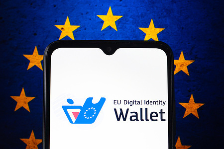 In this photo illustration, the EU Digital Identity Wallet logo is seen displayed on a smartphone and the European Union flag in the background.