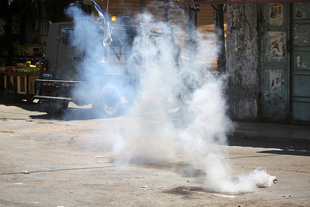 An Israeli military jeep fires a smoke grenade during a raid on Balata refugee camp, east of Nablus in the West Bank. Israeli forces raided the camp and imposed a security cordon around several neighborhoods in search of wanted individuals. Three Palestinians were injured during the operation.