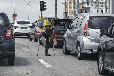 A handicapped man wearing a mask begs on a busy Street at Shah Alam, Selangor.
Malaysian authorities announced that a Conditional Movement Control Order (CMCO) has been issued in several states in an effort to further curb the spread of the coronavirus disease (COVID-19). A CMCO has been issued in Johor, Kedah, Malacca, Negeri Sembilan, Penang, Perak, and Terengganu. The CMCO will remain in place until at least December 6 in the above-mentioned states.