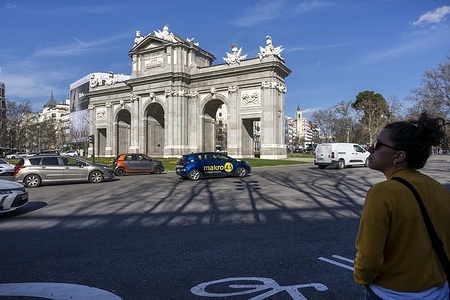 Vehicles seen driving near the gate of Alcalá monument located in the El Retiro district. Madrid is a city renowned for its historical heritage, vibrant tourism scene, and diversity establishing it as one of the continent’s leading cities.