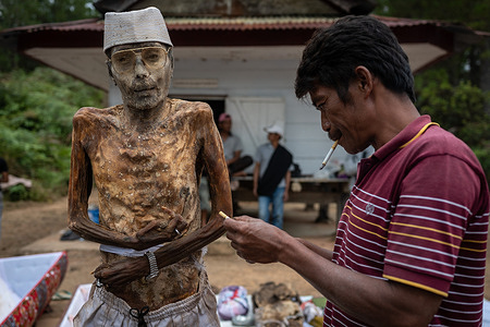(EDITOR’S NOTE: Image depicts death)
Family member cleans the preserved body of a relative during the ritual.
"Manene" is a traditional ritual in Panggala held every three years. Family members gather to clean the graves and change the clothes of their deceased relatives to honour their spirits. The ritual is held before the planting season arrives.