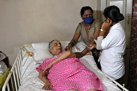 A healthcare worker talks with a young lady before inoculating an elderly woman with a Covaxin, Covid-19 Vaccine at her home in Mumbai.
Indian government is doing a door to door vaccination for the sick, differently abled people who cannot go out of their home to take the vaccine.