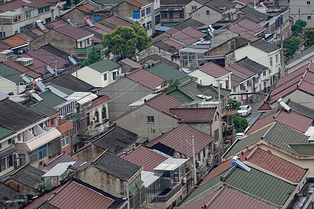 An aerial view of old - style residential areas. There are many low - rise houses with different roof colors, and some trees are scattered among them. China's real estate market, a key part of the economy, has evolved. From rapid growth to stable development, it adapts to urbanization and policy guidance, driving both housing improvement and economic progress.