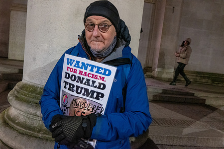 A protester holds a wanted placard featuring picture of Donald Trump during the demonstration. A small protest held in the city centre Manchester UK as a mark of solidarity for the shootings by ICE officers in Minneapolis, USA.