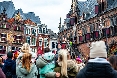 People are seen cheering St. Nicholas. On the first Saturday after November 11th, the red-and-white-clad Sinterklaas (St. Nicholas) arrives in several Dutch cities. In Nijmegen, Sinterklaas entered by following a route through the city center accompanied by his helpers, the Pieten (Peters), who gave traditional candies to children and adults.