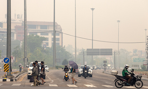 People wearing face masks at an intersection, amid smog in Chiang Mai. The pollution has exceeded the safety level, with the problem likely to get worse. The authorities urged people in Chiang Mai to stay indoors and work from home as air pollution spiked to hazardous levels. Smoke from forest fires and farmers burning crop stubble has blanketed the popular tourist destination in recent weeks.