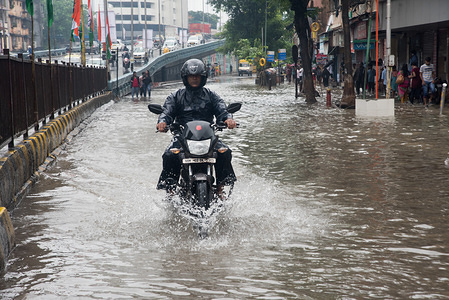 A man seen riding his bike though flooded street.
Heavy rains across Mumbai city and adjoining areas continue for 3rd consecutive day and affect normal life with residents grappling with flooding on road and railway tracks delaying trains and long traffic on the roads most people preferred staying home and those who ventured out got stuck School where also declared holiday for safety of children's in Mumbai.