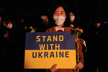 A protester holds a placard saying 'Stand With Ukraine' during the demonstration. Amnesty International held International Corporate Action on the day in Seoul, South Korea, which marks one month since Russia invaded Ukraine.