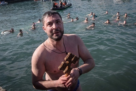 An orthodox believer seen holding a wooden crucifix after catching it during the annual Epiphany Day and the blessing of the waters celebrations in the center of Chania, Greece.
