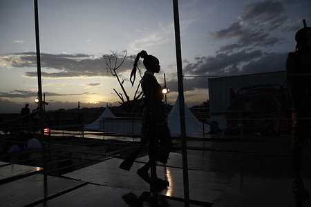A model in silhouette hits the runway at the Kibera Fashion Week, where various fashion designers exhibited their designs in Kibera Slums.