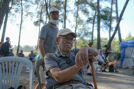 An elderly activist is seen sitting with a stick during the demonstration. The resistance of the people of İkizköy continues against the coal mine that is planned to be opened at the Akbelen Forest in the Milas district of Muğla. As of 5:30 this morning, tree cutting started in the area accompanied by the Gendarmerie and Intervention Vehicle against Social Incidents (TOMA). As a result of the villagers' opposition, the gendarmerie intervened with tear gas and batons. Four people were injured in the incident and many people were detained.