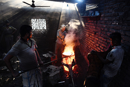 Labourers prepare to pour molten iron in a mould to make a propeller at a workshop on the banks of the Buriganga river in Dhaka.
The shipbuilding industry in Bangladesh is spreading rapidly where workers from all ages work together. The working condition is not suitable for anyone as it is hot and often very dangerous, even workers do not use minimum safety guards and this often leads to accidents.