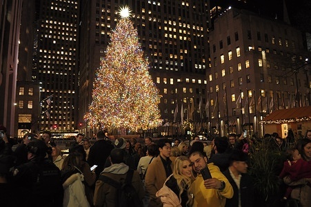 People take photos in front of the Christmas tree at Rockefeller Center in Manhattan.