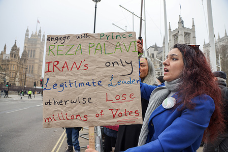 An protester holds a placard during a rally outside the Houses of Parliament in central London. Iranians stage a demonstration calling on the UK to support stronger action on Iran, including proscribing the Islamic Revolutionary Guard Corps (IRGC) as a terrorist organisation, amid criticism of the government’s current stance.