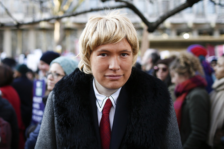 A young man dressed as Donald Trump strikes a pose as demonstrators gather in Grosvenor Square, central London, ahead of the anti-Trump "Women's March", taking place in cities around the world, the day after Donald Trump's inauguration as US president.