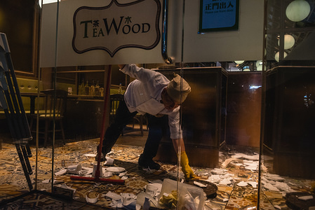 A chef cleans up the pieces of shattered dishes after protesters vandalised the restaurant during the demonstrations.

Protesters gathered at various shopping centers and malls around the city chanting slogans in support of the pro-democracy movement. Protesters later clashed with police in and around the malls as riot police attempted to conduct dispersal operations.
