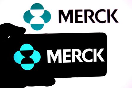 In this photo illustration, the Merck logo is seen displayed on a smartphone and in the background.