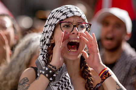 A protester wearing a kufiya shouts slogans during a general strike in Puerta del Sol Square, called by Spanish unions in solidarity with the Palestinians in Gaza.