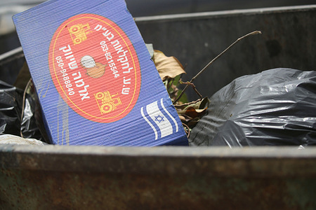 Agricultural products from Israeli settlements, bearing the Israeli flag seen in a garbage container during a boycott campaign against Israeli products and settlements. The operation took place in the Al-Masaken Al-Sha'biya neighborhood, east of Nablus, and included a campaign of arrests targeting Palestinian merchants.