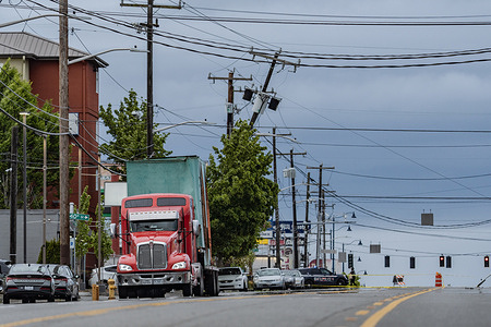 A truck with wires caught on its top, having knocked down power poles along Aurora Ave in Seattle. The incident, which occurred around 5 p.m., led to approximately 770 people losing power, as indicated by the Seattle City Light outage map. Emergency responders were swift to the scene, where a truck was found entangled with wires and had knocked down several power poles, exacerbating the outage.