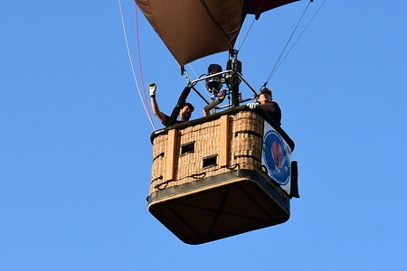 People ride in a hot air balloon during the Hot Air Balloon Festival.