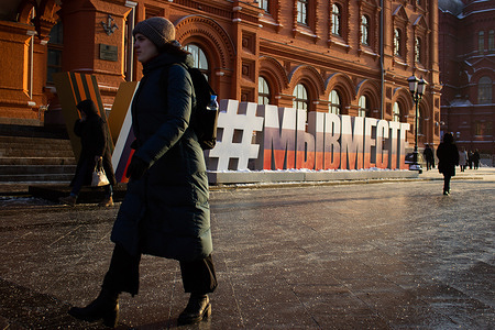 A woman walks by an installation of "Z" and "V" letters on Revolution Square in central Moscow. The text reads, "We are together". Latin script letters "Z" and "V" were first seen painted on Russian military vehicles fighting in Ukraine. Subsequently, it became a symbol of support for the Russian troops inside the country.