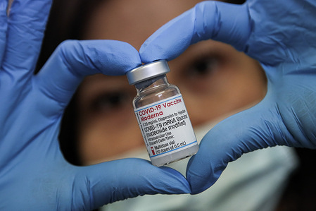 A health worker holds a vial containing Covid-19 booster vaccine at a vaccination centre. 
The government is currently rolling out a booster vaccination program by offering a Covid-19 jab to everyone over the age of 18, by the end of December.