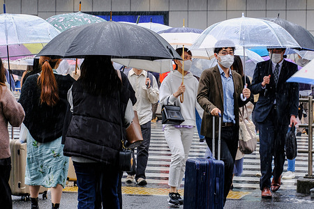 People wear face masks as a preventive measure against the novel coronavirus while walking through the intersection of Shinjuku, Tokyo. The number of coronavirus cases in Japan has gradually started to increase again.