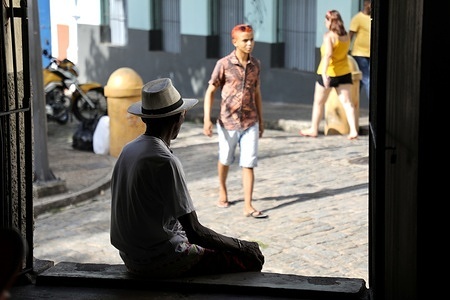 A Brazilian man watches passersby from the front of a store in the historical center of São Luis, Maranhão.