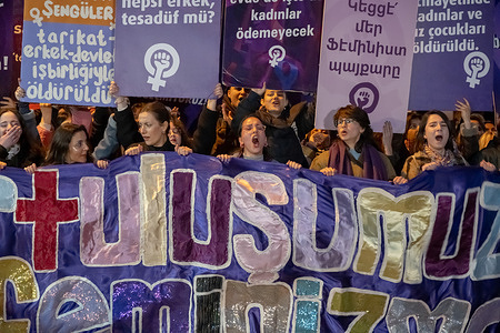 The women are holding a large banner and chanting slogans. On International Women's Day, women gathered in Istanbul's Beyoglu district for a Feminist Night Walk.