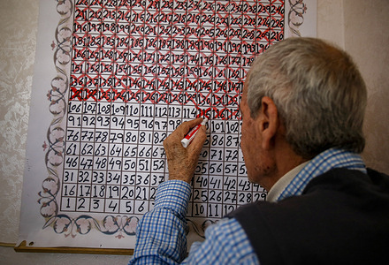 Samih Qadan, 77, the father to a Palestinian prisoner, Abd al-Raouf Qadan, marks his handy calendar created to countdown the number of days remaining to meet his son who has been held in an Israeli prison since 2004, at his home in Rafah, southern Gaza.