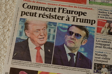 A front page of the daily newspaper Le Dauphiné Libéré seen displayed discussing the tensions between the United States and Europe. A picture of US President Donald Trump and French President Emmanuel Macron is seen on the newspaper.