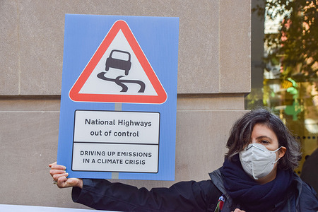 A protester holds a placard critical of National Highways during the demonstration.
Extinction Rebellion's Roads Rebellion activists gathered outside the Department For Transport in protest against the government's plans for building 50 new trunk roads, which will damage the environment and increase carbon emissions.