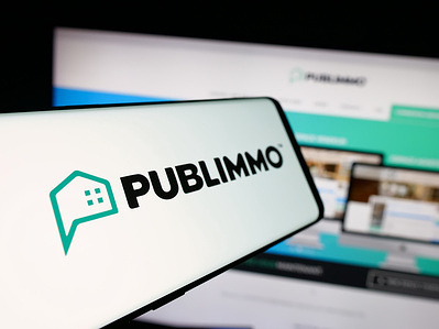 In this photo illustration, a smartphone with the logo of Swiss property software company Publimmo is seen on screen in front of website.