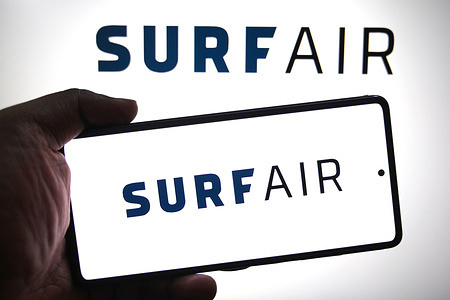 In this photo illustration, a Surf Air logo is seen displayed on a smartphone and in the background.