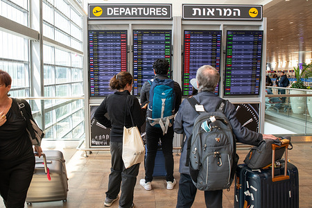 Passengers look at flights announcement board showing delayed flights out of Tel Aviv Ben Gurion Airport due to a strike by the Workers Union following Prime Minister Benjamin Netanyahu’s dismissal of the Minister of Defense Yoav Gallant.