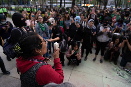 Mother to a murdered female activist speaks to the women during the march.
Hundreds of women attended the first feminist march of 2020 in Mexico City surrounded by hundreds of female police officers. The women used paint, fire to threaten police and men who came close to them. The women were campaigning for change in Mexico. The march was for female activists who had been assassinated, specifically Isabel Cabanillas and Yunuen L—pez S‡nchez.