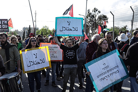 Left-wing Israeli peace activists and Palestinians march with Palestinian national flags and placards during a demonstration. A demonstration against the eviction of Palestinians from their homes in the neighbourhood of Sheikh Jarrah in Israeli-annexed East Jerusalem.