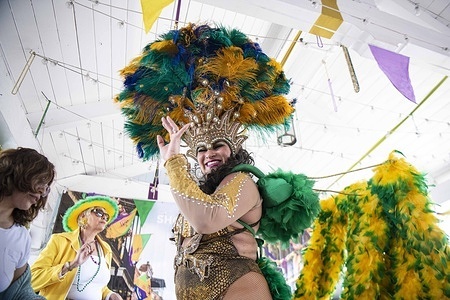 A Mardi Gras parade performer dances with the crowd at one of the attraction points during the Mardi Gras parade route. The City of Long Beach, California hosted a Mardi Gras celebration inviting citizens far and wide to join in on the parade, which included a short walk through downtown Long Beach with attractions along the way. The event included bead throwing, live music, dancing and a ton of laughs for everyone who decided to attend.