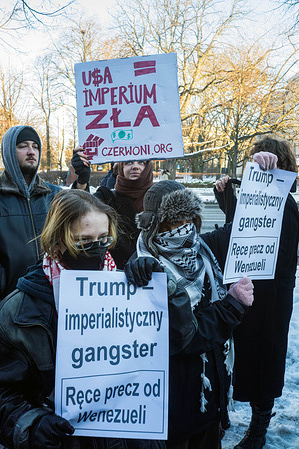 Protesters hold anti-imperialist and anti-Trump placards during the rally.. Anti-war and anti-imperialist protesters gathered outside the American embassy in Warsaw to protest against Donald Trump's illegal attack on Venezuela and the kidnapping of the Venezuelan leader, Nicolas Maduro and his wife. Activists spoke to the small gathering of protesters who held placards, flags, and chant anti-imperialist slogans.