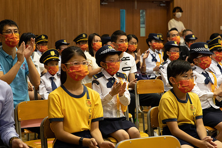 A young student claps her hands, during the ceremony.
National education activities and flag-raising ceremony were held at a secondary school in Siu Sai Wan. As China and Hong Kong government officials are eliminating any sign of dissent since the establishment of National Security Law, a new form of national education has been formed where students are taught to be more patriotic and have sensitive-loyal to their motherland.