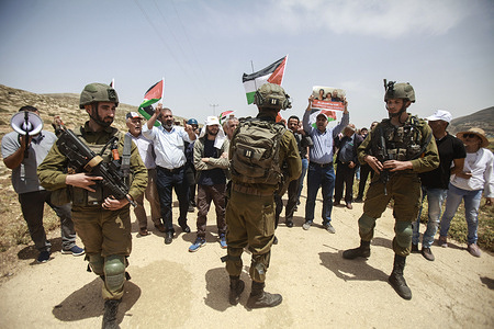 Palestinian protesters confront Israeli soldiers with Palestinian flags, during the demonstration near the Jewish settlement of Elon Moreh, east of Nablus. Palestinian protesters confront the Israeli security forces during a protest against the establishment of Israeli outposts, in Beit Dajan, near Elon Moreh's settlement, east of the occupied West Bank city of Nablus.