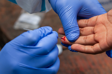 LALITPUR, NEPAL - APRIL 14, 2020:
A health worker wearing gloves takes blood samples from a man who has a recent travel history outside the country at the makeshift rapid testing center for Coronavirus (COVID-19) in Lalitpur.
Nepal has conducted 12,609 tests for COVID-19 so far and out of them, 16 cases were confirmed.