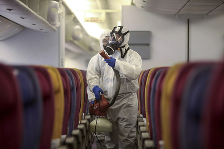 SAMUT PRAKAN, THAILAND - JANUARY 28, 2020:
Crew member in a protective suit and mask spraying during the disinfection process.
Thai Airways International spray disinfectant on passenger seats all plane following a risky corona virus infection. Thailand has detected 14 cases, Thai health officials are stepping up monitoring and inspection. The virus has so far killed at least 106 people an outbreak which began in the Chinese city of Wuhan.