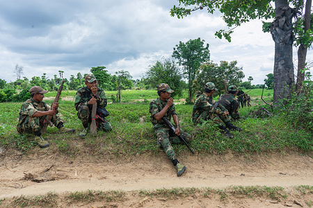 Soldiers from the Battalion 12 of the People's Defence Force (PDF) in Shwe Bo District take a break during a patrol exercise. The People's Defence Force (PDF) operates under the Ministry of Defence of the National Unity Government (NUG), a rival government. As of May 2025, the NUG claims to have formed over 300 PDF battalions.